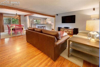 Living room featuring light wood-type flooring, a chandelier, beamed ceiling, and recessed lighting