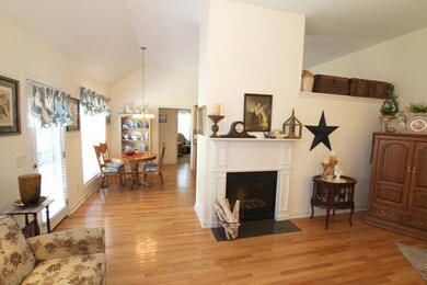 living room looking to electric fireplace and kitchen 