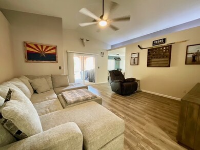 Living room featuring ceiling fan, light wood-styl