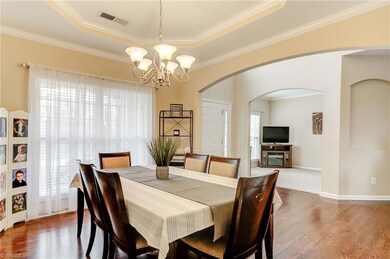 A regal oversized formal dining room with octagon trey ceiling and hardwoods.