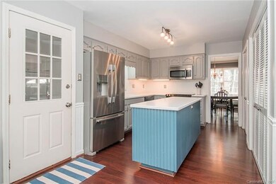 Kitchen with island, painted cabinets and stainles