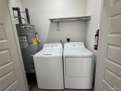 Laundry area featuring electric water heater and washer and dryer
