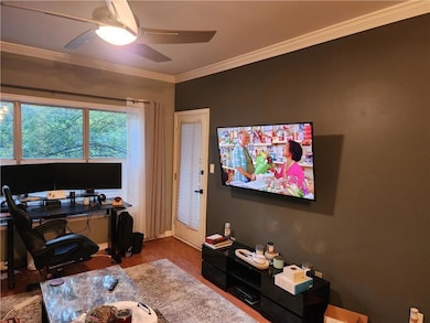Office space featuring crown molding, wood finished floors, and a ceiling fan