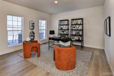 Home office with light wood-style floors and recessed lighting