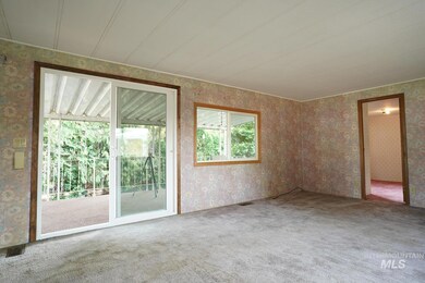 Carpeted empty room featuring wallpapered walls
