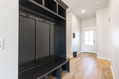 Mudroom featuring baseboards and light wood-style floors