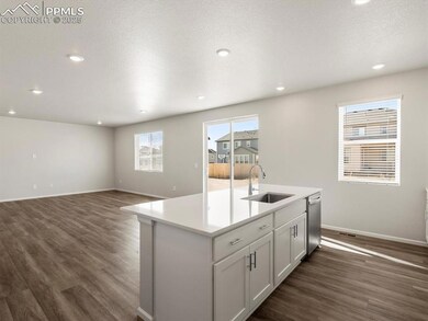 Kitchen with white cabinetry, a center island with sink, dark wood finished floors, recessed lighting, and a textured ceiling