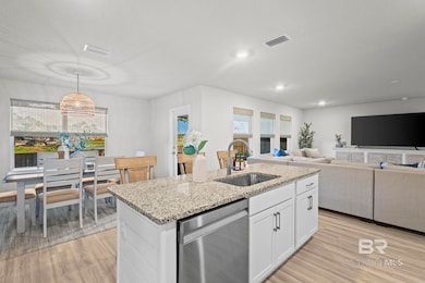 Kitchen featuring dishwasher, light wood-style floors, a center island with sink, white cabinetry, and recessed lighting