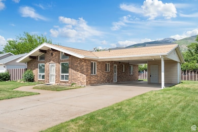 View of front facade with a carport, concrete driveway, brick siding, and a mountain view