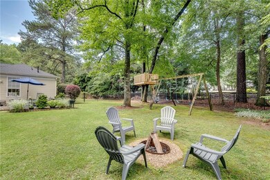 Enjoy outdoor living space in the flat fenced-in backyard, which is reminiscent of a park- it contains a tree house, swing set, zip line, ninja line with hanging obstacles, Pawleys Island hammock, picnic table, firepit, and a large shed for storing a