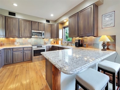 Kitchen with stainless steel appliances, a peninsu