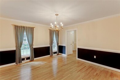 Formal dining room has oak floors, chair rail and 