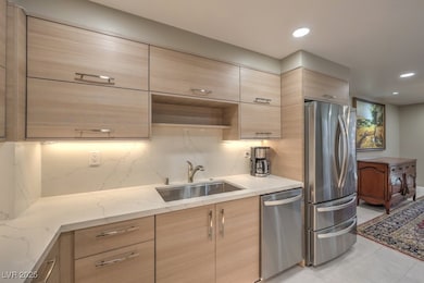Kitchen with light brown cabinets, a sink, and app
