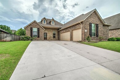 View of front of home featuring a garage, concrete driveway, roof with shingles, and brick siding