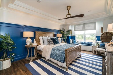 Main floor master bedroom suite.  Including tray ceiling with crown molding, can lighting, window bench and wide plank hardwood flooring