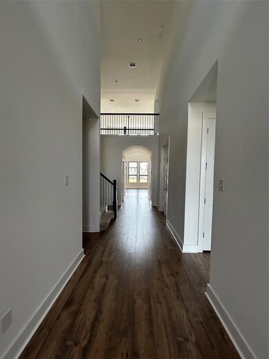 Hallway featuring arched walkways, dark wood fini