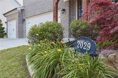 Community / neighborhood sign featuring a garage and driveway