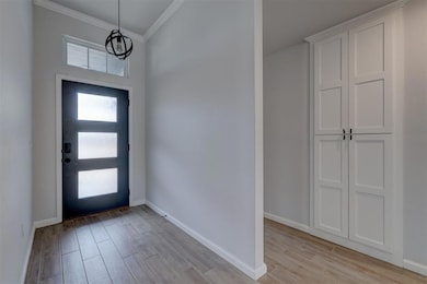 Entryway featuring crown molding and light wood-type flooring
