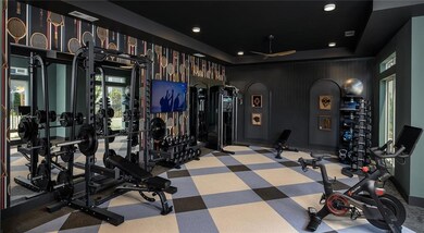 Workout area featuring a tray ceiling and recessed lighting