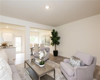 Living area with light wood-type flooring and recessed lighting