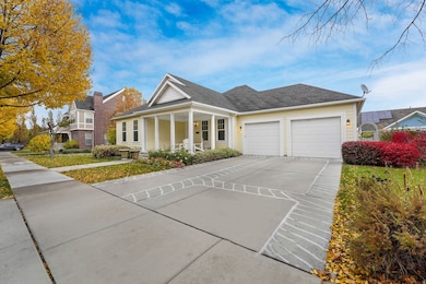 View of front of property with a porch, concrete driveway, an attached garage, and roof with shingles
