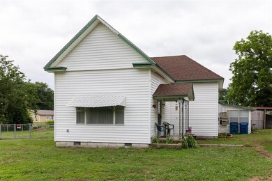 Rear view of house with a yard and a storage unit