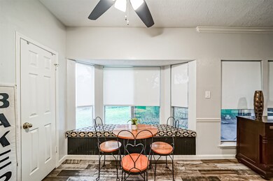 Tucked at the far end of the kitchen, this eat-in breakfast room boasts a built-in bench seat with bonus storage space, bathed in abundant natural sunlight streaming in through the bay window with light-filtering roller shades.