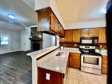 Kitchen featuring kitchen peninsula, a textured ce