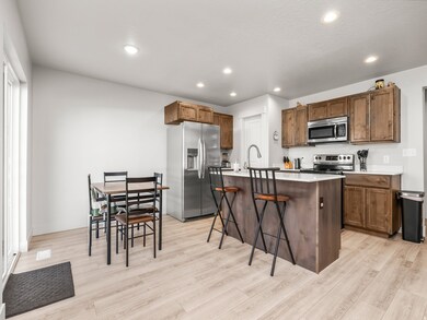 Kitchen featuring stainless steel appliances, recessed lighting, a center island with sink, a kitchen breakfast bar, and light wood finished floors