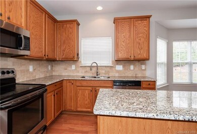 Kitchen boasts full granite, new tile backsplash, 