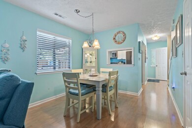 Dining room with a textured ceiling and wood finished floors