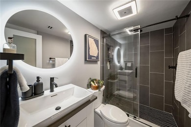 Modern full bathroom featuring contemporary finishes, waterfall shower, a large vanity, and a clean, spa-like design.