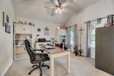 Home office featuring light carpet, vaulted ceilin
