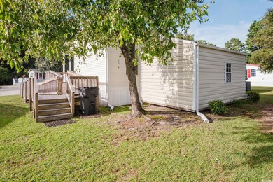 Rear view of house featuring a lawn and a deck
