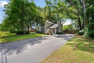 View of front facade with driveway and a chimney