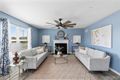 Living area with light wood finished floors, a fireplace with flush hearth, and a ceiling fan