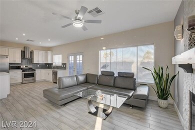 Living room featuring a fireplace, a ceiling fan,