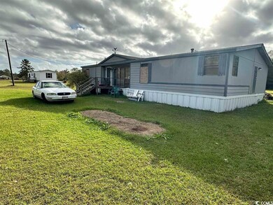 View of side of property featuring a lawn