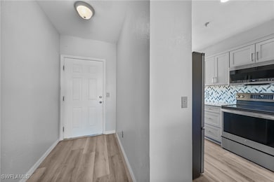 Hallway featuring baseboards and light wood finish