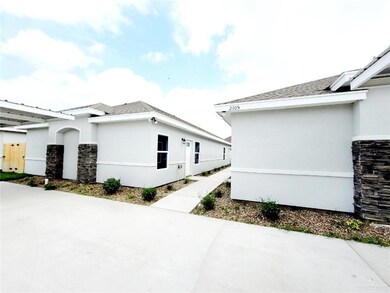 View of home's exterior featuring stone siding, stucco siding, a patio, and roof with shingles