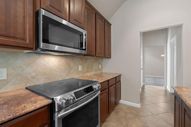 Kitchen featuring stainless steel appliances, lig