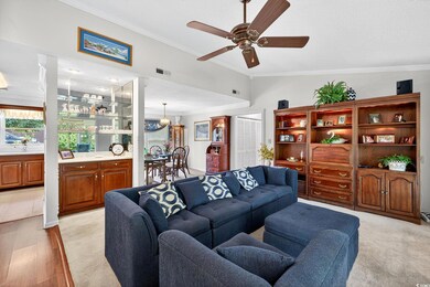 Living area with crown molding, a ceiling fan, vaulted ceiling, and light wood-style floors