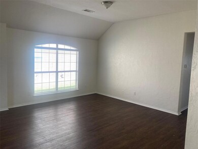 Empty room featuring lofted ceiling and dark hardw