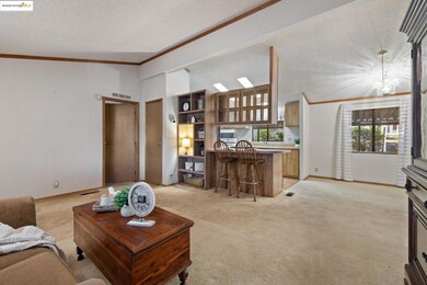 Living room with light carpet, crown molding, lofted ceiling, a textured ceiling, and a chandelier