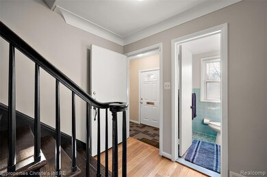 Staircase with wood finished floors and tile walls