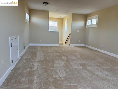 Carpeted spare room with baseboards