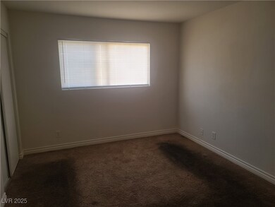 Carpeted empty room featuring baseboards
