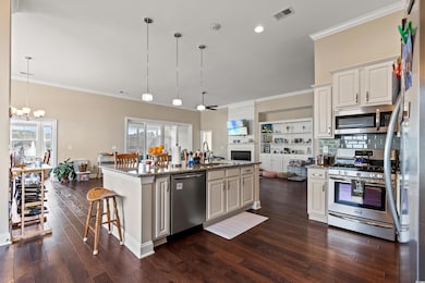 Kitchen with dark wood-style floors, visible vents