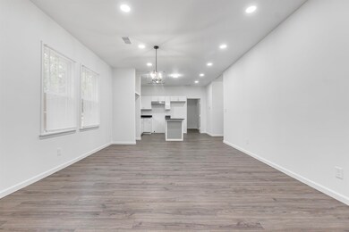 Unfurnished living room featuring a notable chandelier, recessed lighting, visible vents, and baseboards