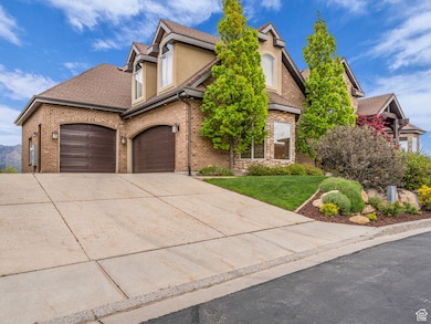 View of front of home featuring concrete driveway, stucco siding, a front yard, an attached garage, and brick siding